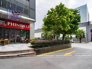 ein Gebäude mit einem Baum mitten auf einer Straße in der Unterkunft Lani Living - Residence & Hotel in District 1 in Ho-Chi-Minh-Stadt