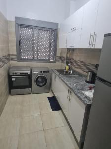 a small kitchen with a stove and a sink at Charmant appartement pour votre séjour a Bouskoura a Casablanca in Bouskoura