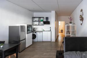 a kitchen and living room with a refrigerator and a table at Apartment mit vier Einzelboxspringbetten - Netflix in Goch