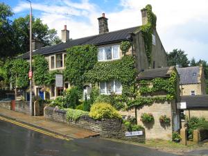 an ivy covered house on the side of a street at Rosebud Cottage Guest House in Haworth