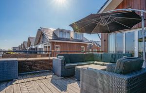 eine Terrasse mit einer Couch und einem Sonnenschirm in der Unterkunft Oostergeest Beneden 2 Slaapk in Uitgeest