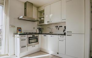 eine weiße Küche mit weißen Schränken und einer Spüle in der Unterkunft Oostergeest Beneden 2 Slaapk in Uitgeest