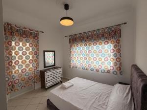 een slaapkamer met twee gordijnen en een bed en een ladekast bij Residence Anuar T in Tetouan