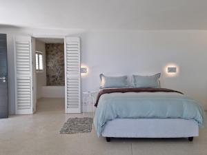 ein weißes Schlafzimmer mit einem großen Bett und einem Badezimmer in der Unterkunft 'Kaya Moya' - Luxury Suite for 2 with Ocean Views in Gordonʼs Bay
