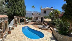 a backyard with a swimming pool and a house at Boutique Villa Jina, Private Pool, Mountain View, Near Nerja, Quiet Location, Mediterranean Garden in Torrox