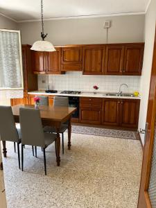 a kitchen with wooden cabinets and a wooden table with chairs at Il Tulipano - Villa con giardino in Bionde di Visegna