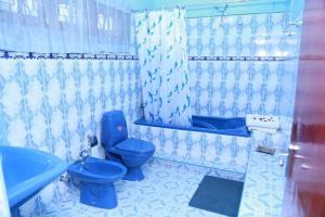 a bathroom with a blue toilet and a bath tub at Juliyanvilla in Kandy +27 photos