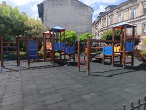 a playground with blue chairs in a park at Rafaelo Władycze 17/4 in Przemyśl
