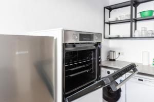 a stainless steel refrigerator with an open oven in a kitchen at Apartment - 3 Einzelbetten - Stellplatz - Netflix in Goch