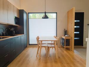 a kitchen with a table and a window with blinds at Kinosmaja in Syöte