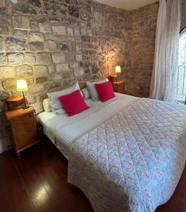 a bedroom with a large bed with red pillows at The Konoba in Šibenik