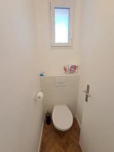 baño con aseo blanco y ventana en Chambre d'hôte centre-ville Manosque, en Manosque