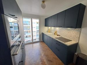 una cocina con armarios azules y una gran ventana en Chambre d'hôte centre-ville Manosque, en Manosque