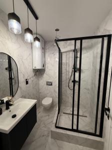 une salle de bain avec douche, lavabo et toilettes dans l'établissement Апартаменти SeaGems, à Karolino-Buhaz