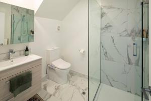a bathroom with a toilet and a glass shower at Luxury Apartment Christchurch Central in Christchurch