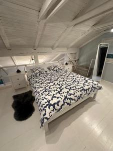 a bedroom with a bed with a black and white comforter at Lawenda in Turawa