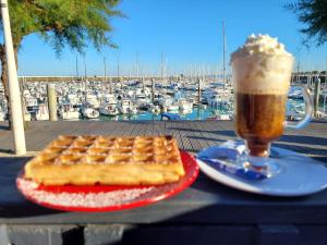 a pie and a drink on a table with a marina at Notre Oléronaise in Saint-Denis-dʼOléron