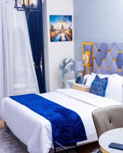 a bedroom with a large bed with a blue blanket at Pretty haven-studio apartment -Kilimani in Nairobi