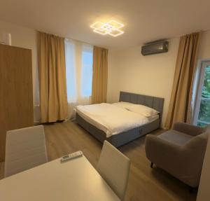 a bedroom with a bed and a table and a chair at Apartmány Hviezdoslavova in Piešťany