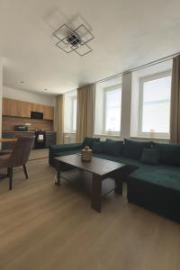 a living room with a green couch and a table at Apartmány Hviezdoslavova in Piešťany