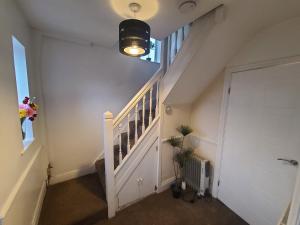 a hallway with a staircase with a light and a door at Starlet Single Room in Manchester