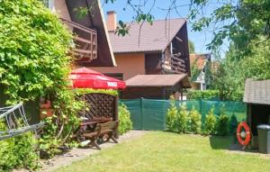 Un patio con una casa con una sombrilla roja en 4 Bedroom Stunning Home In Rowy, en Rowy