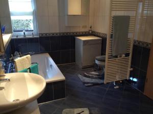 a bathroom with a sink and a tub and a toilet at Ferienwohnung In Neustrelitz Mit Garten Und Grill in Neustrelitz