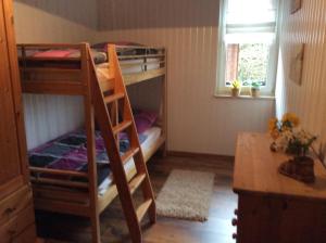 a bunk bed room with two bunk beds and a desk at Ferienwohnung In Neustrelitz Mit Garten Und Grill in Neustrelitz