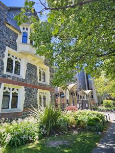a large brick building with a garden in front of it at Luxury Apartment Christchurch Central in Christchurch