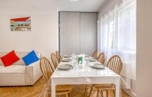 ein weißes Esszimmer mit einem weißen Tisch und Stühlen in der Unterkunft Appartement Proche Plage in Royan