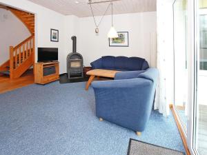 a living room with a blue couch and a wood stove at Ferienanlage im Mueritz-Nationalpark in Mirow in Mirow +66 photos