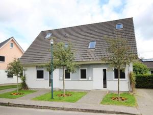 a white house with a gray roof and two trees at Ferienanlage im Mueritz-Nationalpark in Mirow in Mirow