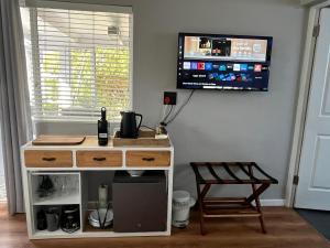 a room with a tv on a wall with a desk at Almond Cottage in Riebeek-Kasteel