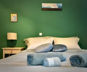 a green bedroom with a bed with pillows on it at Zoe City Home in Corfu