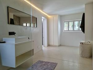 ein Badezimmer mit Waschbecken und Spiegel in der Unterkunft 'Kaya Moya' - Luxury Suite for 2 with Ocean Views in Gordonʼs Bay