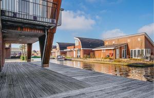 ein Holzsteg mit Häusern und einem Fluss in der Unterkunft Westergeest Beneden 2 Slaapk in Uitgeest
