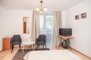 a bedroom with a bed and two chairs and a television at Hubertus Rewal in Rewal
