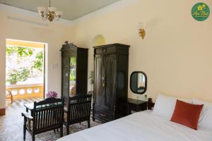 une chambre avec un lit, des meubles et un miroir dans l'établissement An Thư Home Garden, à Hue