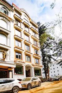 two cars parked in front of a building at Beautiful Sapa Hotel in Sa Pa