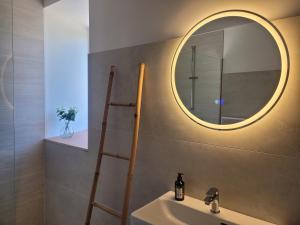 a bathroom with a sink and a mirror on the wall at La Maison en Brocéliande in Paimpont
