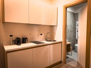 una cucina con mobili bianchi e un lavandino di Alma Guest House a Roma