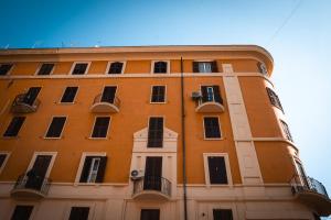 un alto edificio arancione con finestre e balconi di Alma Guest House a Roma
