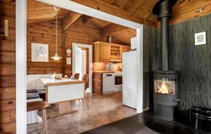 a kitchen with a fireplace in a wooden house at Nice Home In Tarm With Swimming Pool in Tarm