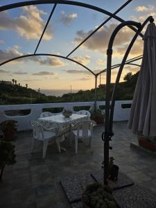 a patio with a table and chairs and an umbrella at Bosa appartamento Bouganville con vista mare ampio terrazzo in Magomadas