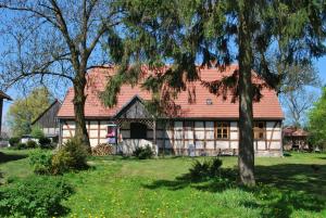 ein großes weißes Haus mit rotem Dach in der Unterkunft Zagroda Chłopska in Gosław