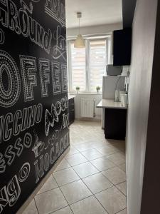 a kitchen with a black wall with writing on it at Centrum Apartament in Gdańsk +11 photos
