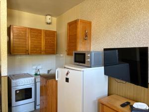 a kitchen with a white refrigerator and a microwave at Studio Centre Vars Le Seignon in Vars