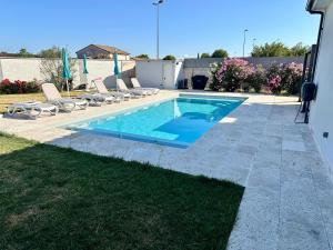 a swimming pool with lounge chairs next to a house at Chambre agréable, SDB privée, Clim, Vue Piscine, in Muret