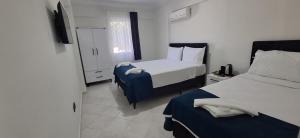 a hotel room with two beds and a window at Bizim Kelebek Otel in Fethiye
