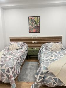 two beds sitting next to each other in a bedroom at Hostal Jimena restaurante el Porvenir in Martiherrero